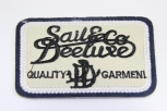 0303/15/388/00/49332 - Emblem ,Polyester, ca. 60 mm x80 mm , schwarz/ beige