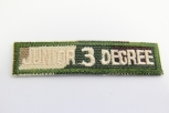 0303/15/415/54 - Emblem , Polyester, ca. 57x 14 mm , grün/ beige